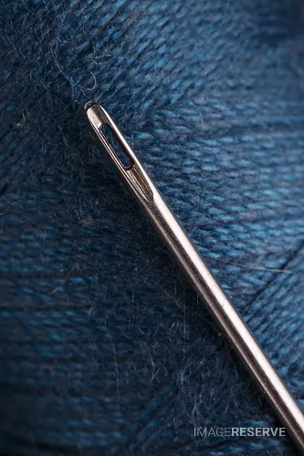 Macro View of Sewing Needle and Blue Thread